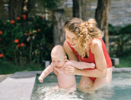 mother holding her baby in the swimming pool